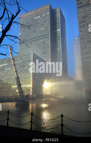 JP Morgan Hochhaus erhebt sich über Winternebel clearing von Canary Wharf Wasserstraßen mit Sonne reflektieren Verglasung London Docklands Tower Hamlets UK Stockfoto