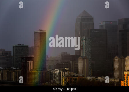 London, UK. 5. März 2016. UK-Wetter: Bunten Regenbogen Pausen bei einem Sonnenuntergang Gewitter über Canary Wharf Business park Gebäude Credit: Guy Corbishley/Alamy Live News Stockfoto