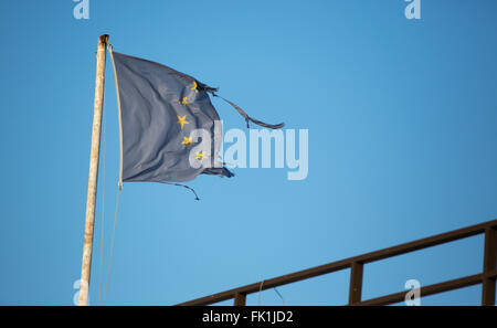 Vathy, Griechenland. 1. März 2016. Eine zerrissene Fahne der Europäischen Union Wellen am Passagierterminal im Hafen von Vathy auf der Insel Samos in Vathy, Griechenland, 1. März 2016. Mehrere Länder haben in den vergangenen zehn Tagen Flüchtling Kappen und Grenze Controll eingeführt. Dies hat einen großen Rückstand von Flüchtlingen in Griechenland geschaffen. Foto: Christian Charisius/Dpa/Alamy Live News Stockfoto