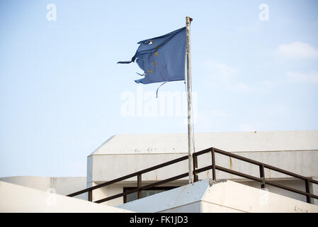 Vathy, Griechenland. 1. März 2016. Eine zerrissene Fahne der Europäischen Union Wellen am Passagierterminal im Hafen von Vathy auf der Insel Samos in Vathy, Griechenland, 1. März 2016. Mehrere Länder haben in den vergangenen zehn Tagen Flüchtling Kappen und Grenze Controll eingeführt. Dies hat einen großen Rückstand von Flüchtlingen in Griechenland geschaffen. Foto: Christian Charisius/Dpa/Alamy Live News Stockfoto