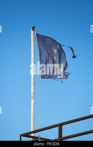 Vathy, Griechenland. 1. März 2016. Eine zerrissene Fahne der Europäischen Union Wellen am Passagierterminal im Hafen von Vathy auf der Insel Samos in Vathy, Griechenland, 1. März 2016. Mehrere Länder haben in den vergangenen zehn Tagen Flüchtling Kappen und Grenze Controll eingeführt. Dies hat einen großen Rückstand von Flüchtlingen in Griechenland geschaffen. Foto: Christian Charisius/Dpa/Alamy Live News Stockfoto