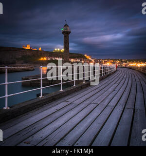 Nachtzeit zu fotografieren, Rückblick auf die Lichter von Whitby an der North Yorkshire Küste von West Pier Ausdehnung Stockfoto