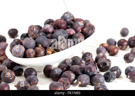 Wacholderbeeren auf einem weißen Holztisch Stockfoto