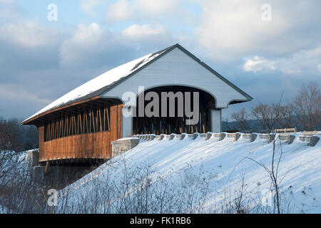 Sonne bricht durch die Wolken über Holz- brücke nach Schneefall in Neu-England. Stockfoto