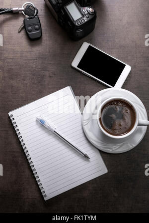 Kaffee-Pause des Fotografen. Tasse Kaffee, weißen Smartphone und Kamera auf Holztisch. Stockfoto