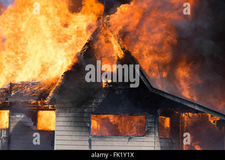 Ein Haus wird durch Flammen in einem lodernden Feuer verbraucht. Stockfoto