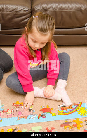 Drei-jährigen Mädchen lernen, wie man Puzzle zu tun. Stockfoto