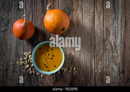 Hokkaido Kürbissuppe mit Kürbisse auf rustikalen hölzernen Hintergrund. Einige negative Raum um. Stockfoto