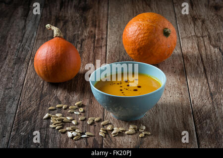 Hokkaido Kürbissuppe mit Kürbisse auf rustikalen hölzernen Hintergrund. Stockfoto