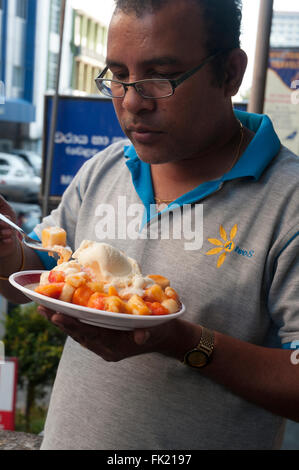 Sri Lanka Büroangestellter genießen frischer Obstsalat mit Eis in einem Geschäft im Stadtteil Fort, Colombo Stockfoto