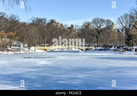 Die Bogenbrücke ist ein Gusseisen-Brücke befindet sich im Central Park in New York City, Crossing-Over The Lake und als ein Fußgänger wal Stockfoto