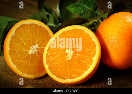 Gruppe von Orangen mit Blättern auf Holzbrettern. Stockfoto