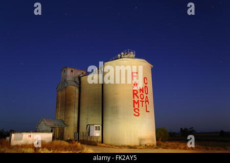 Vor der Morgendämmerung Lichtmalerei der Getreidesilos an der Liverpool Plains, New South Wales, Australien. Die Silos haben "Farmen Kohle nicht" aufgemalt. Stockfoto