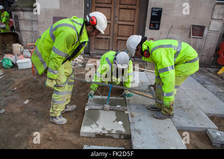 Arbeiter, die Verlegung von Pflastersteinen in London Stockfoto