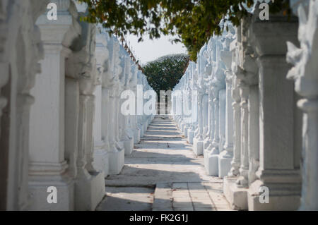 Schmale Gasse flankiert von langen Reihen von weißen Säulen Kuthodaw Pagode, Mandalay, Myanmar (Burma). Stockfoto