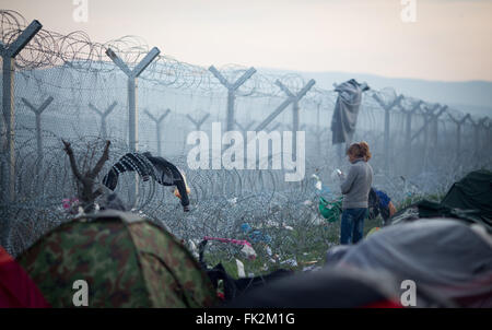 Idomeni, Griechenland. 6. März 2016. Eine Frau stand am Zaun an der griechisch-mazedonischen Grenze in der Nähe von Idomeni, Griechenland, 6. März 2016. Nur wenige Flüchtlinge aus Syrien und dem Irak werden über die Grenze nach Mazedonien jeden Tag vermietet werden. Foto: KAY NIETFELD/Dpa/Alamy Live News Stockfoto