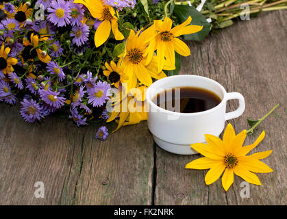 weiße Tasse Kaffee und Blumenstrauß Stockfoto