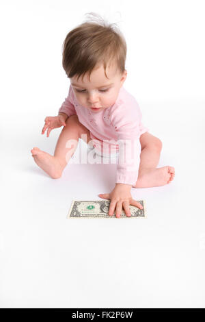 Babymädchen ist Abholung einen Dollar vom Boden auf weißem Hintergrund Stockfoto