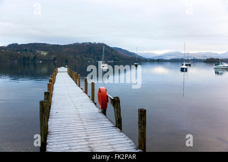 Segelboote und ein Pier am See WIndemere in den frühen Morgenstunden - Cumbria, England Stockfoto