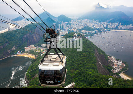 Ein Kabel-Cart hinunter Zuckerhut (Pão de Açúcar) in Rio De Janeiro, Brasilien mit Christus der Erlöser Statur vor Stockfoto