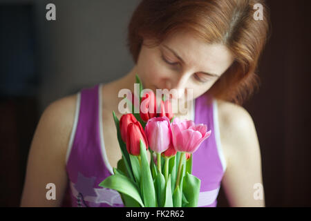 Haufen von Tulpen in den Händen der Frau. Das Ferienhaus von Lenz und Liebe. Internationaler Frauentag am 8. März. Stockfoto