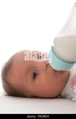 Baby bekommt Fläschchen auf weißem Hintergrund Stockfoto