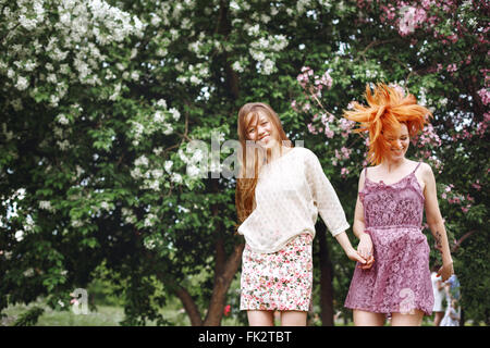 Zwei junge hübsche Mädchen, die Spaß im Freien im Sommerpark. Freiheit-Jugendkonzept. Glückliche Frau Lachen und springen. Stockfoto