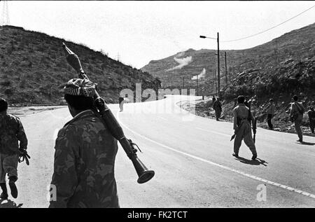 In der Nähe von Zakho, Norden des Irak, Kurdistan. März 1991. Kämpfer aus Kurdistan vorne bewegen in Richtung Front mit irakischen Regierungstruppen während des Aufstands von Kurden gegen die Truppen der Regierung Saddam Husseins. Explosionen von Raketen abgefeuert durch Angriffe auf Kampfhubschrauber können in den Hügeln in Mittelrahmens gesehen werden. Stockfoto