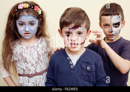 Zombie-Apokalypse-Kinder-Konzept. Geburtstag Party Feier Schmink auf Kinder Tote Braut, Narbe Gesicht, Skelett zusammen Stockfoto