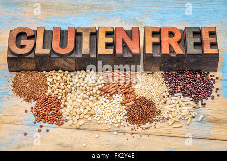 eine Auswahl an Gluten frei Körner (Quinoa, Reis, Teff, Buchweizen, Hirse, Kaniwa, Amaranth) und Text im Vintage Holz-Art Stockfoto