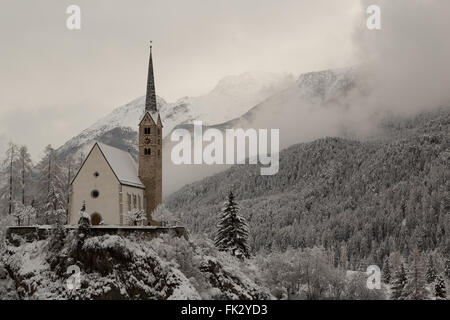 Winter hat einen späten Auftritt in der reformierten Kirche in Scuol im Kanton Graubünden, Schweiz. Stockfoto