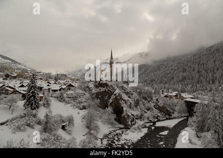 Winter hat einen späten Auftritt in der reformierten Kirche in Scuol im Kanton Graubünden, Schweiz. Stockfoto