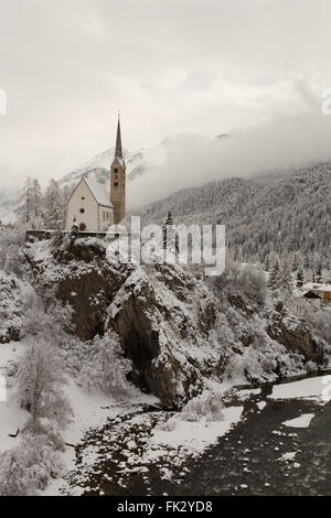 Winter hat einen späten Auftritt in der reformierten Kirche in Scuol im Kanton Graubünden, Schweiz. Stockfoto