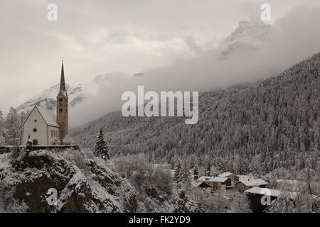 Winter hat einen späten Auftritt in der reformierten Kirche in Scuol im Kanton Graubünden, Schweiz. Stockfoto