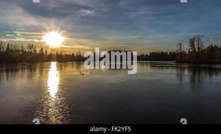 Sonnenuntergang über teilweise gefrorenen Mühle See in Abbotsford British Columbia im westlichen Kanada Stockfoto