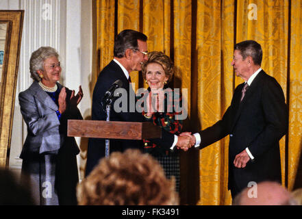 15. November 1989 - Washington, District Of Columbia, Vereinigte Staaten von Amerika - US-Präsident George H.W. Bush schüttelt Hände mit ehemaligen US-Präsidenten Ronald Reagan, da er bei der Präsentation der offiziellen Porträts von Präsident Reagan und First Lady Nancy Reagan im East Room des weißen Hauses in Washington, D.C. am 15. November 1989 amtiert.  Von links nach rechts: Barbara Bush, Präsident Bush, Nancy Reagan, ehemaliger Präsident Reagan... Bildnachweis: Ron Sachs / CNP (Kredit-Bild: © Ron Sachs/CNP über ZUMA Draht) Stockfoto