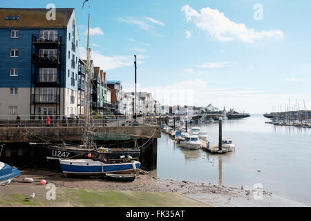 Blick entlang der Littlehampton Hafen zu Fuß mit Eigenschaften, die mit Blick auf Fluss Arun West Sussex UK Stockfoto