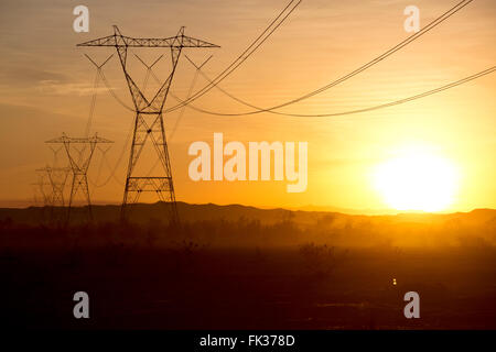 Hochspannung Stromleitungen und die untergehende Sonne in der Sonoran Wüste, Kalifornien, USA Stockfoto