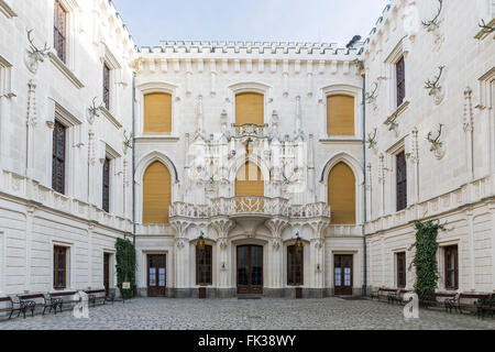 Innenhof Schloss Hluboka. Schöne gotische Elemente an den Wänden. Wände mit Geweih geschmückt. Hluboka nad Vltavou. Stockfoto