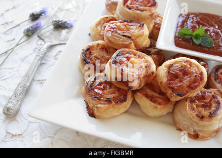 Hausgemachte Pizza Hawaii rollt auf weißem Teller mit Tomatensauce Stockfoto