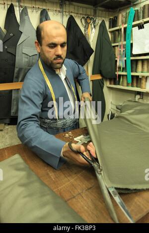 Ein kurdischer Schneider in seiner Werkstatt in Erbil Basar. Stockfoto