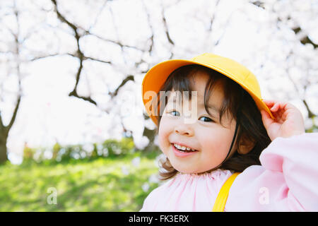 Lächelnde japanische Mädchen genießen Kirschblüten in einem Stadtpark Stockfoto