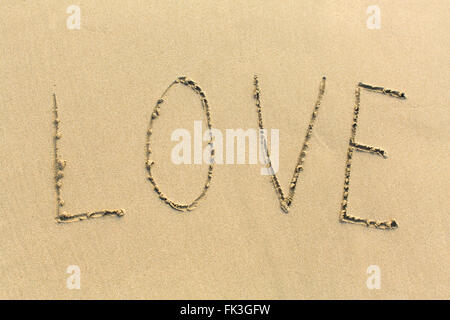 Liebe - Wort gezeichnet am Sandstrand. Stockfoto