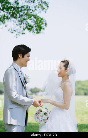 Japanische Braut und Bräutigam in einem Stadtpark Stockfoto