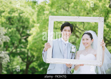 Japanische Braut und Bräutigam in einem Stadtpark Stockfoto