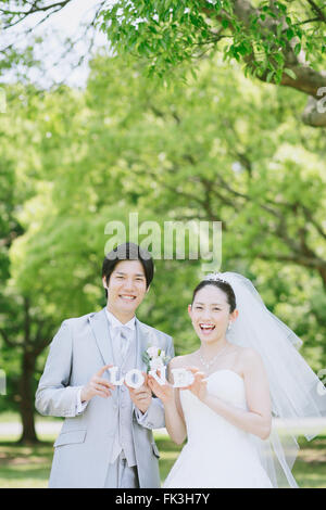 Japanische Braut und Bräutigam in einem Stadtpark Stockfoto