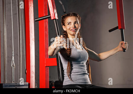 Junge attraktive Frau Sportler auf ein Sport-Simulator trainieren. Sportclub. Fitness-Club. Gesunder Lifestyle-Konzept. Stockfoto