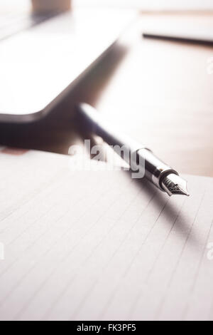 Bild mit hoher Auflösung, zeigt einen Schreibtisch-Arbeitsbereich mit Tagesordnung, Stift, Laptop, Telefon. Stockfoto