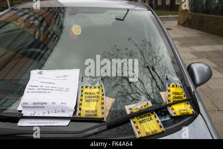 Drei gelbe Tickets für eine Strafgebühr an einer Windschutzscheibe in London, England, Großbritannien Stockfoto