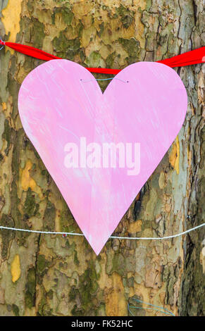 Rosa Papierherz an einen Baum gebunden Stockfoto